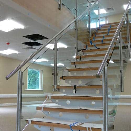 Glass panel balustrade for stairs and floor above in an office building