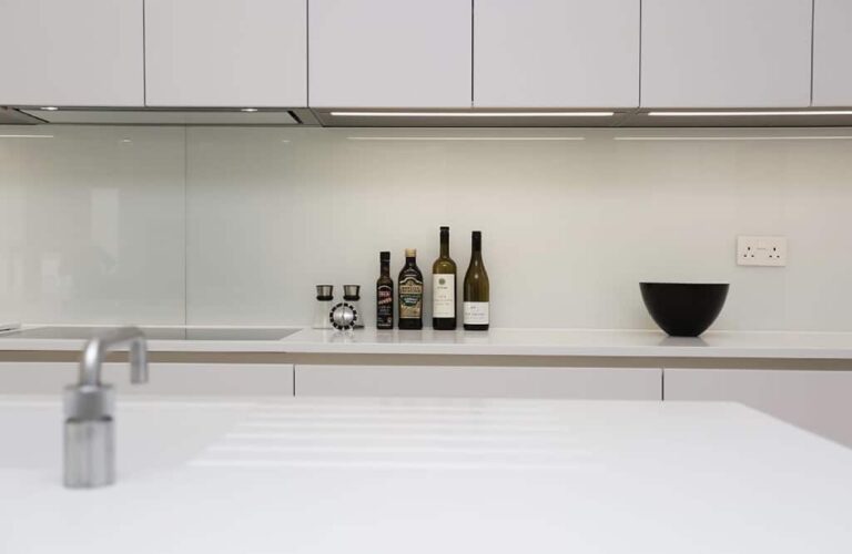 Clear glass kitchen splashback with lights under cupboards