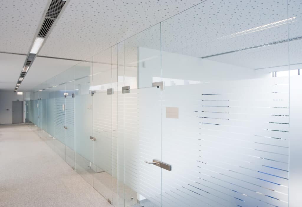 A transcluent glass office partition stretching along a corridor