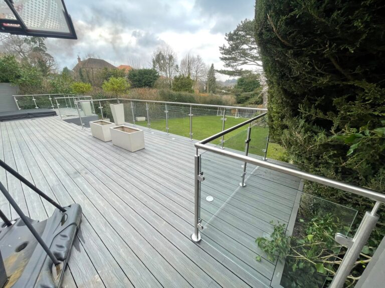 Large area of decking with a glass balustrade around the edges