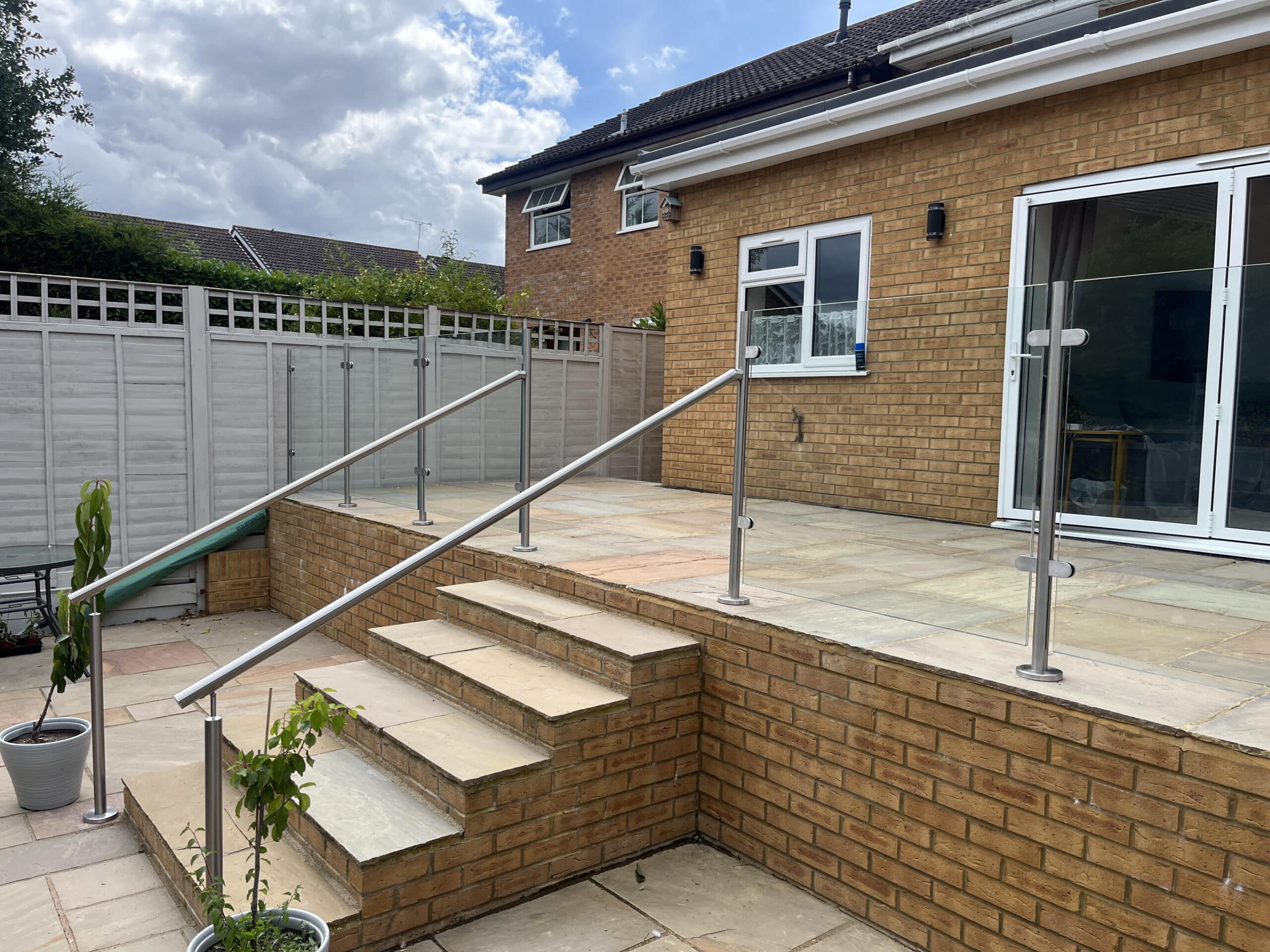 Glass balustrade on patio with posts down the stairs